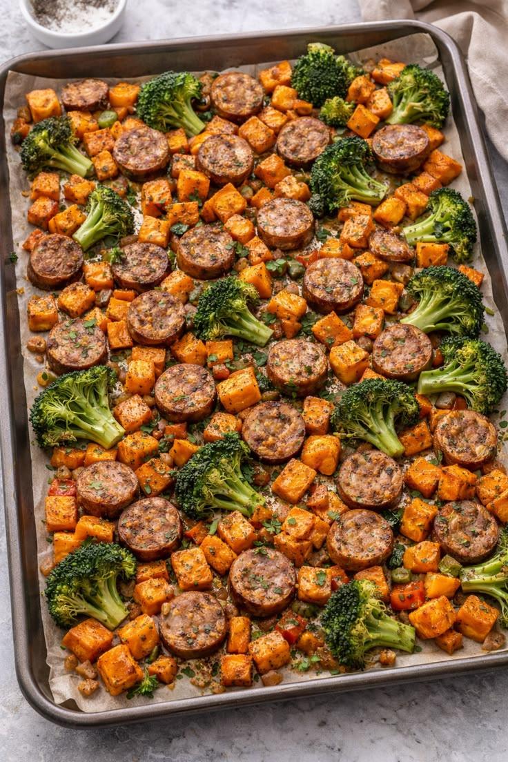 Sheet pan with roasted sweet potatoes, sausage, and broccoli.