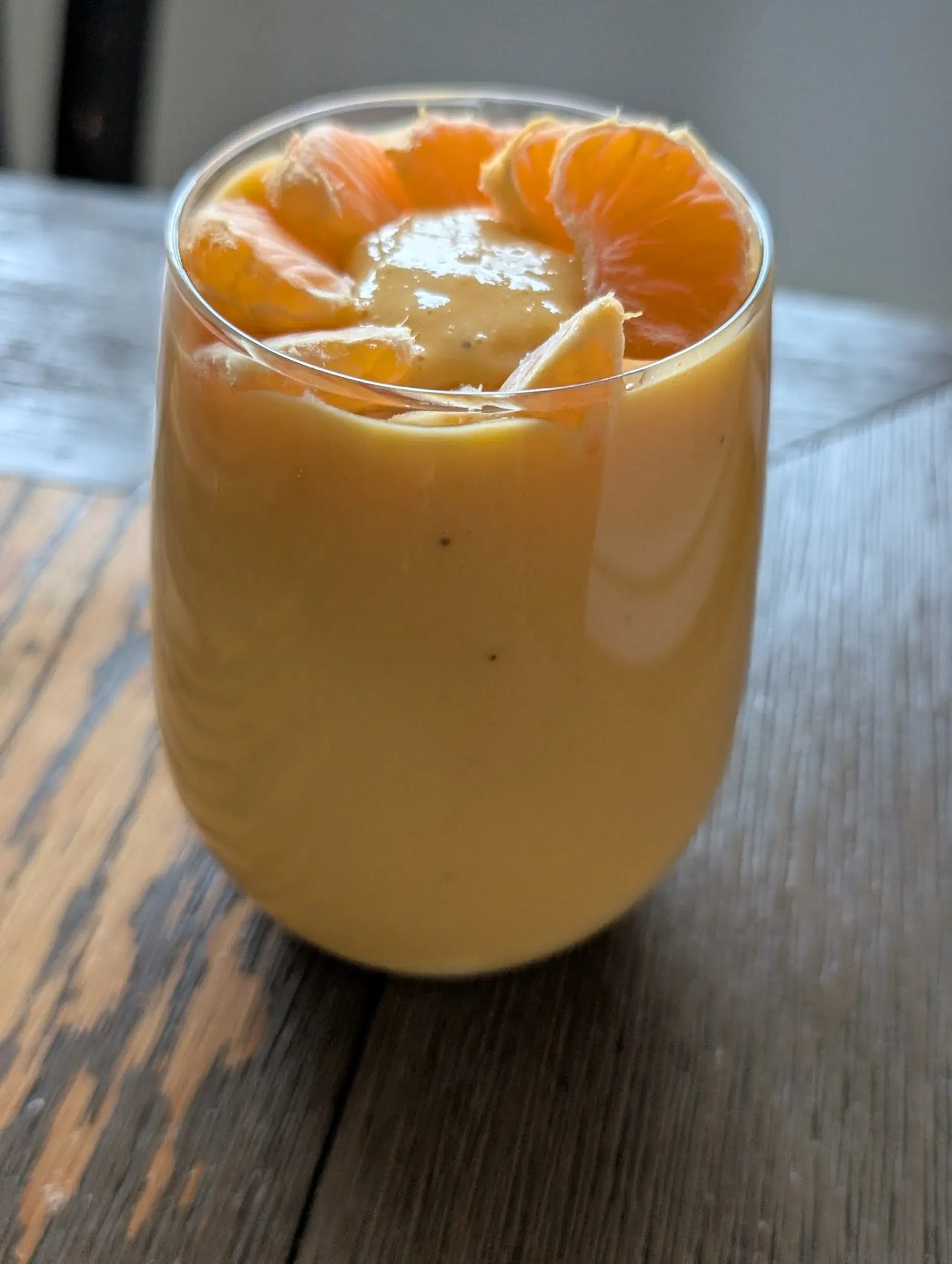 Creamy orange smoothie served cold in a glass.