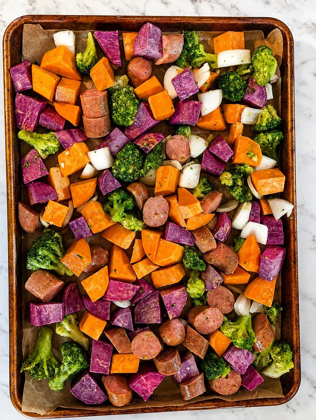 Sheet pan with roasted sweet potatoes, sausage, and broccoli.